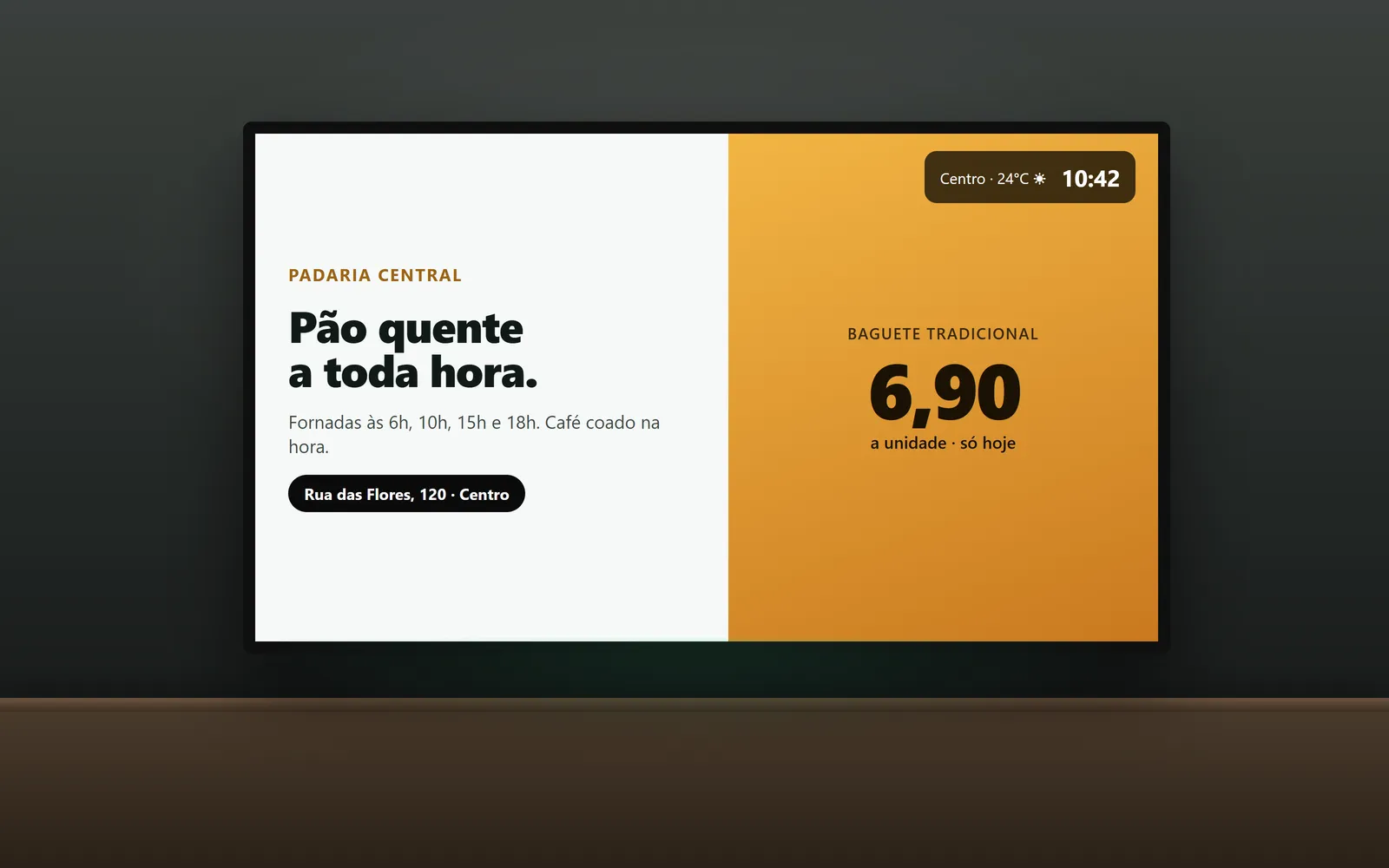 Uma TV na parede de uma loja exibindo a campanha de um anunciante, com o clima e a hora no canto